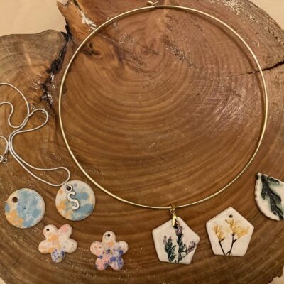 Katie Beasley - Art Clay Love - Ceramic pendant shapes with coloured imprinted patterns on chains.