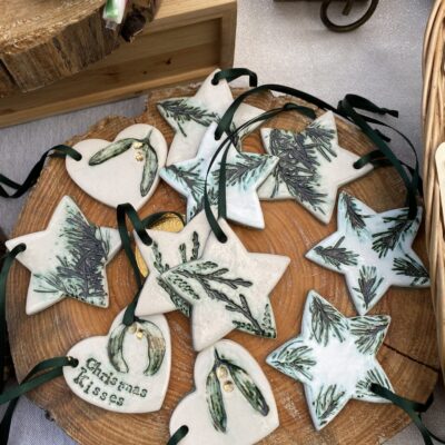 Katie Beasley - Art Clay Love - Ceramic Christmas decorations.  White clay heart with imprinted mistletoe and hand stamped words 'Christmas Kisses'  and stars with imprinted natural fir tree fronds decorated in dark green oxide and a gold berry.