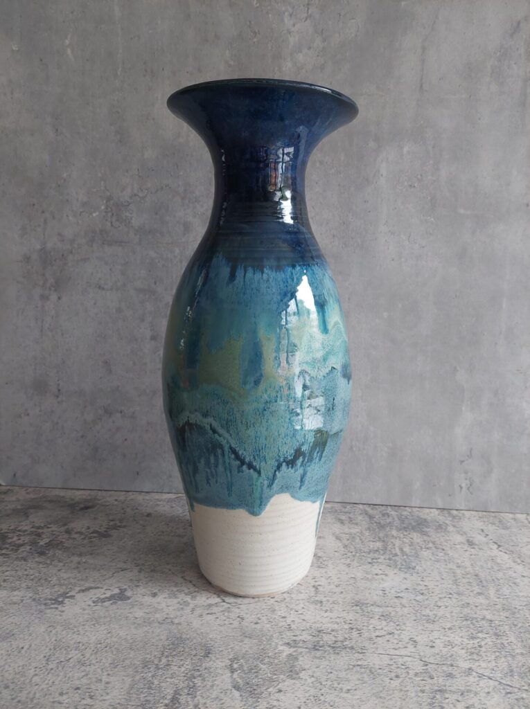 Tall stoneware seascape vase, glazed in glossy blues and greens.