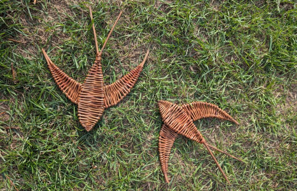 A pair of swallow sculptures, created with woven willow.